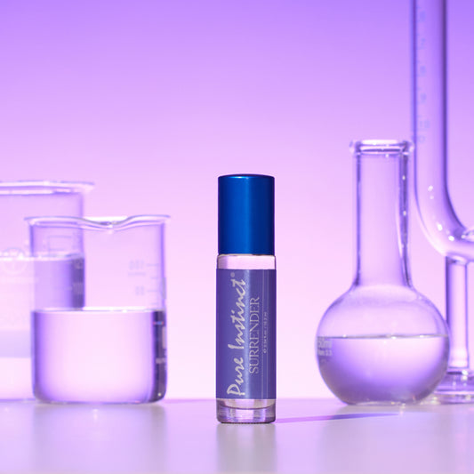 Surrender Roll-On Pheromone Perfume Oil standing among scientific beakers and flasks under a violet glow, highlighting a clean and sophisticated vibe