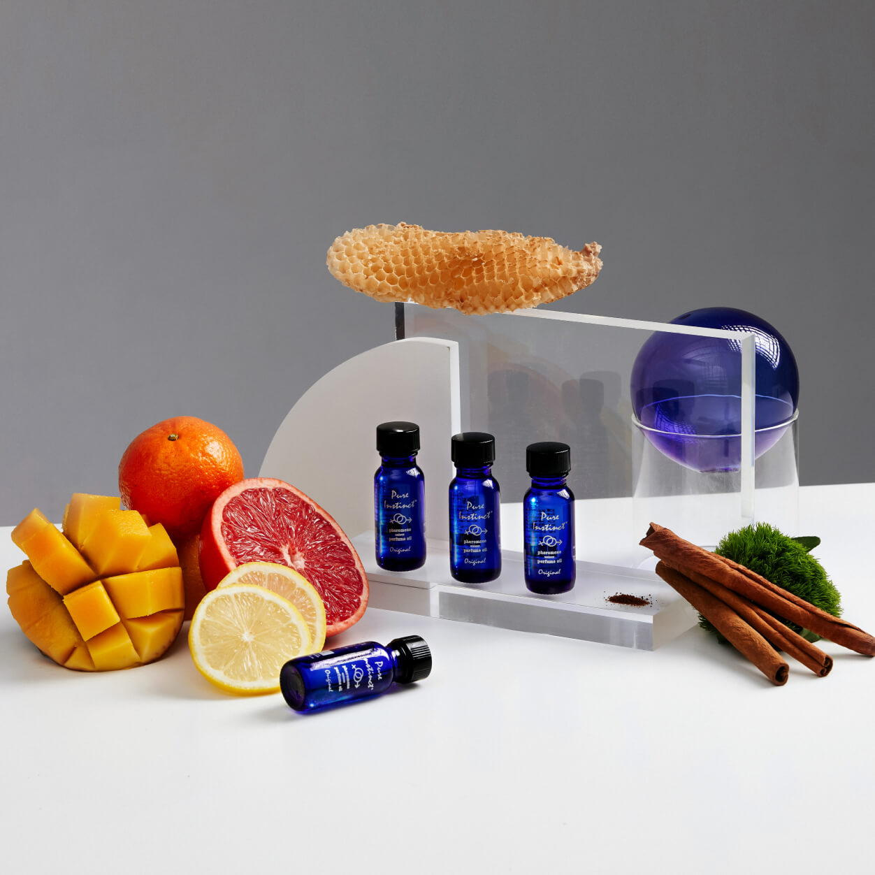 Pure Instinct ORIGINAL essential oil surrounded by fresh fruits, spices, and natural elements highlighting fragrance inspiration